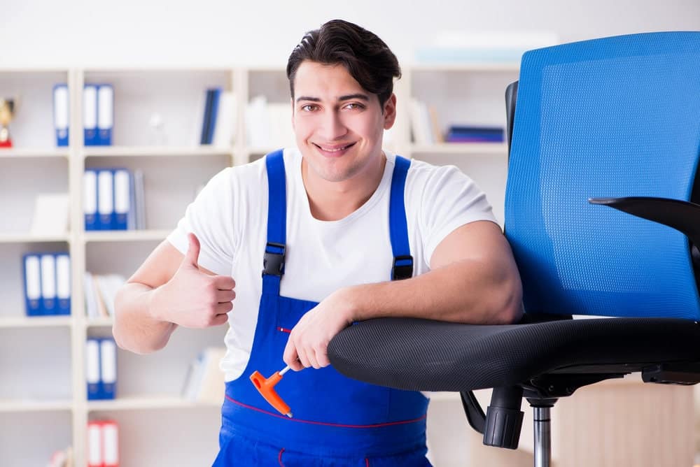 A man fix the recline function of office chair - Cadeira Escritorio IND
